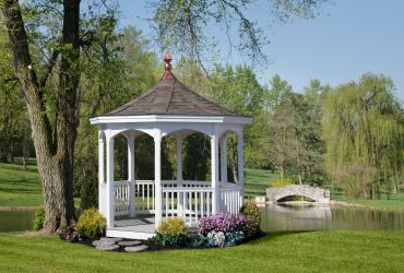 White vinyl octagon gazebo beside pond