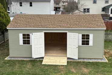 Sage colored shed front view with doors open.