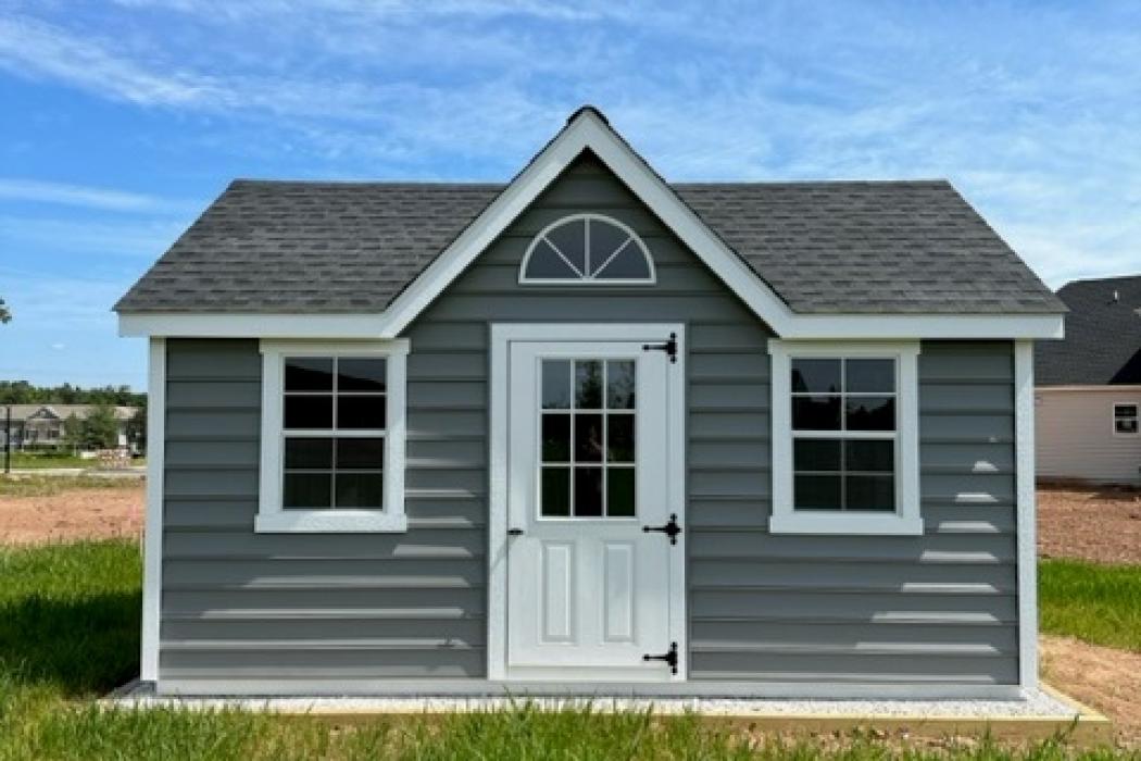 grey-blue victorian style shed. photo taken from the front.